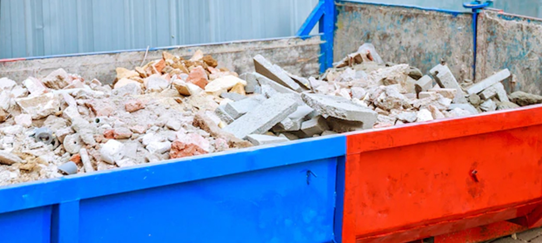 Photo of construction materials in a red and blue skip