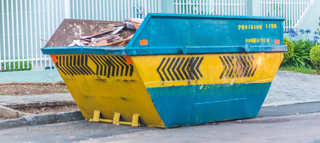 Photo of a small blue & yellow skip.