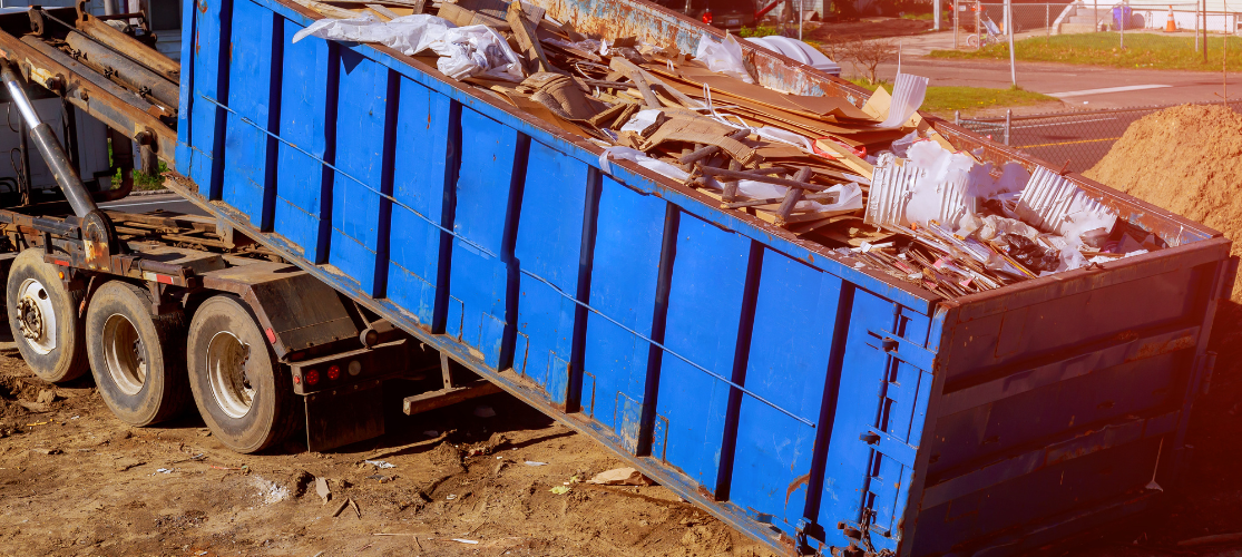 Header image showing construction skip being loaded off of a truck to be recycled.